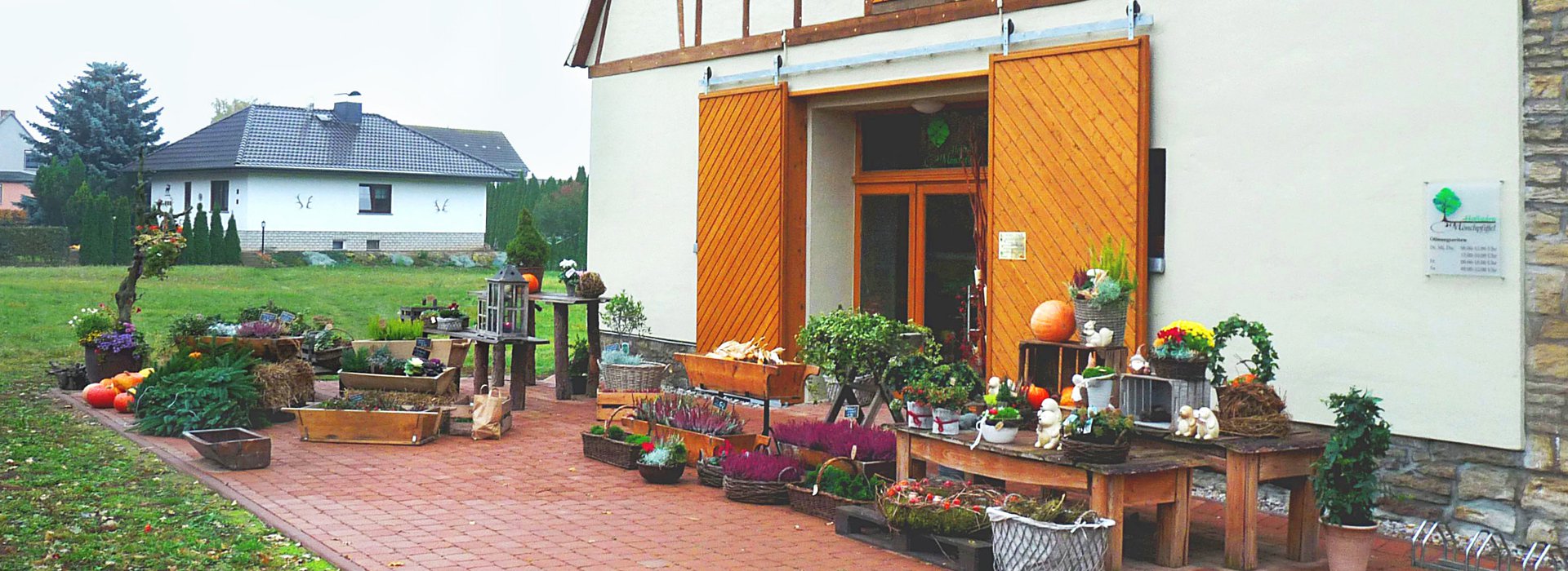 Hofladen Landhaus mit einer imposanten Holztür, die den Zugang zu einem charmanten Innenraum ermöglicht.