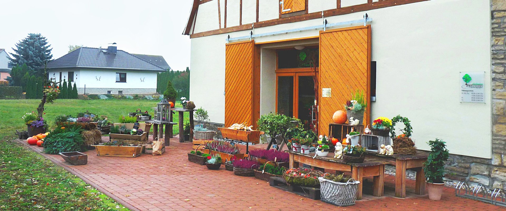 Hofladen Landhaus mit einer imposanten Holztür, die den Zugang zu einem charmanten Innenraum ermöglicht.