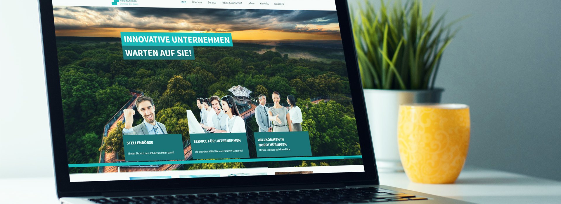 Nordthüringen Laptop hat eine Website geöffnet, kleine Deko-Pflanzen im Hintergrund