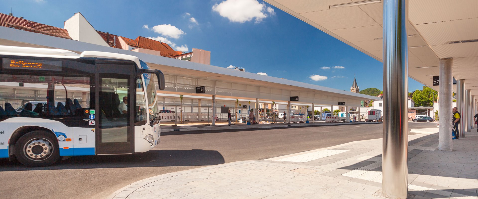 Ein weiß-blauer Bus steht an einem modernen Busbahnhof
