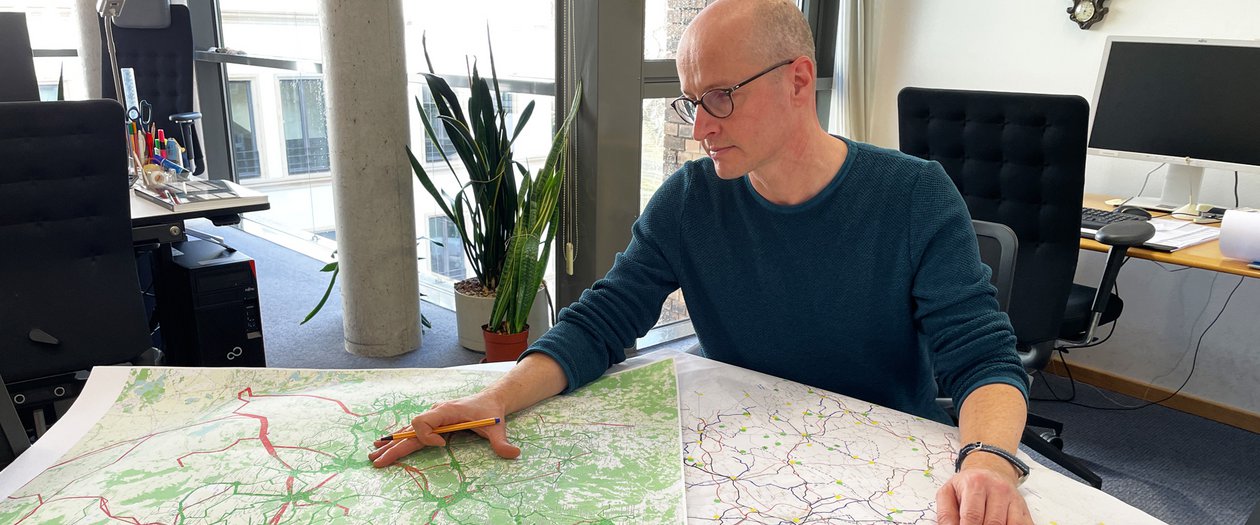 Mehr Erreichbarkeit Eine Person zeigt Standorte auf einer Landkarte im Büro