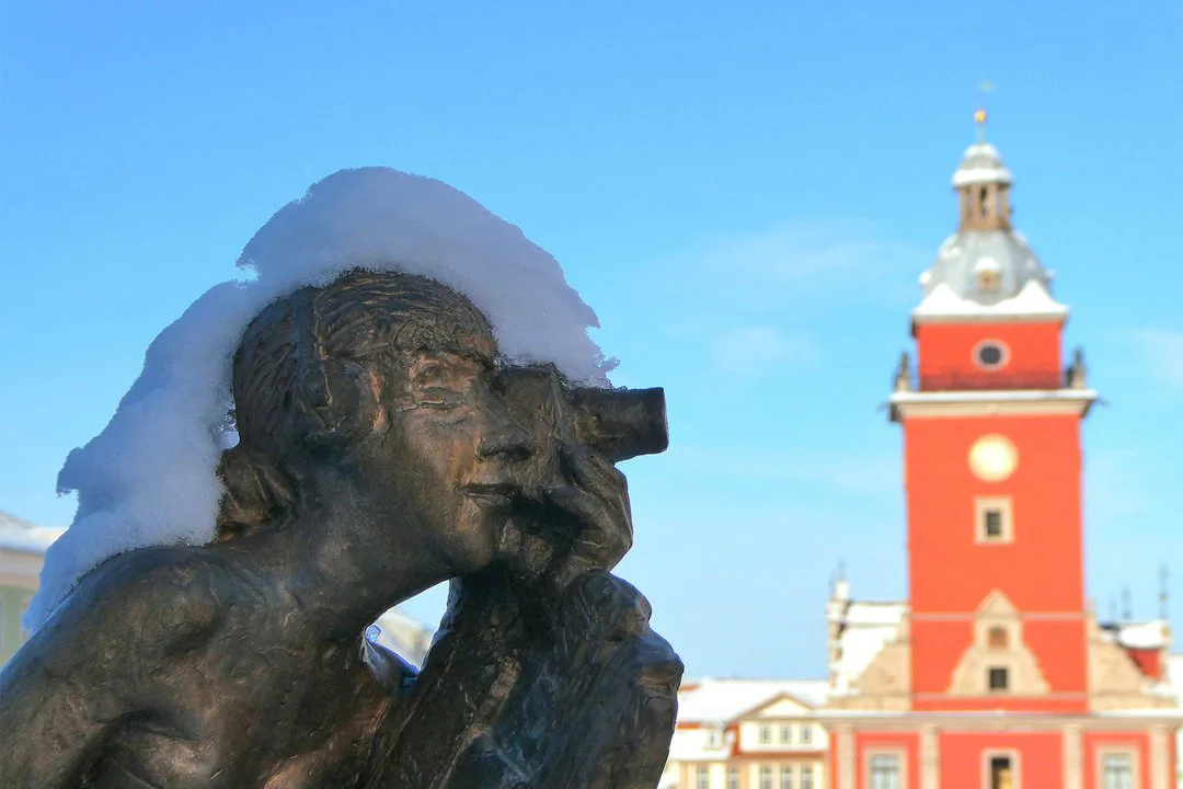 Britta Böttger, Oberer Hauptmarkt in Gotha Eine Person mit Kamera als Statue, im Vordergrund eines roten Gebäudes.