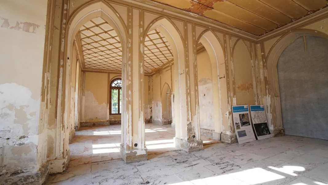 Innenraum des Schlosses mit Stuckdecke und Türbögen