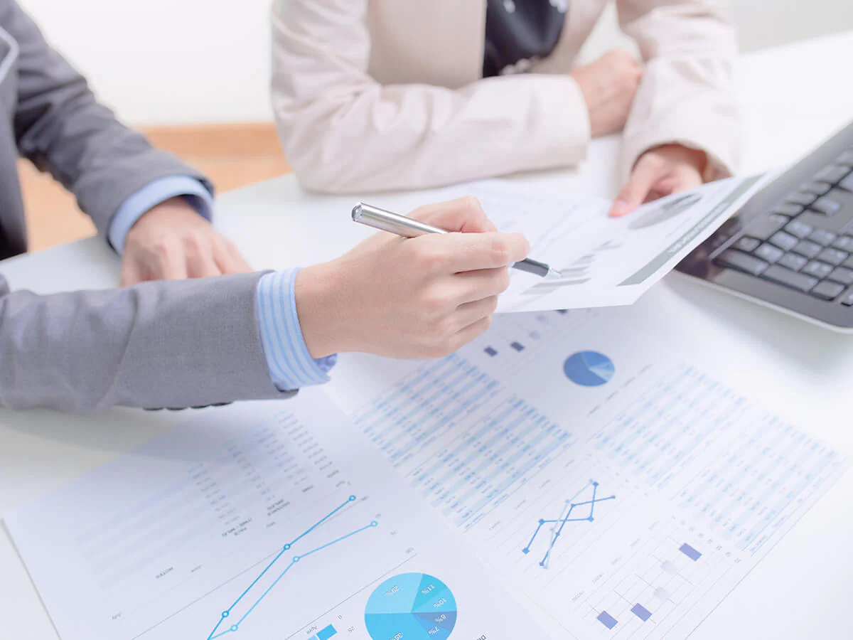 Bildbeschreibung / description: 2 Menschen sitzen gemeinsam über Dokumenten und einem Laptop