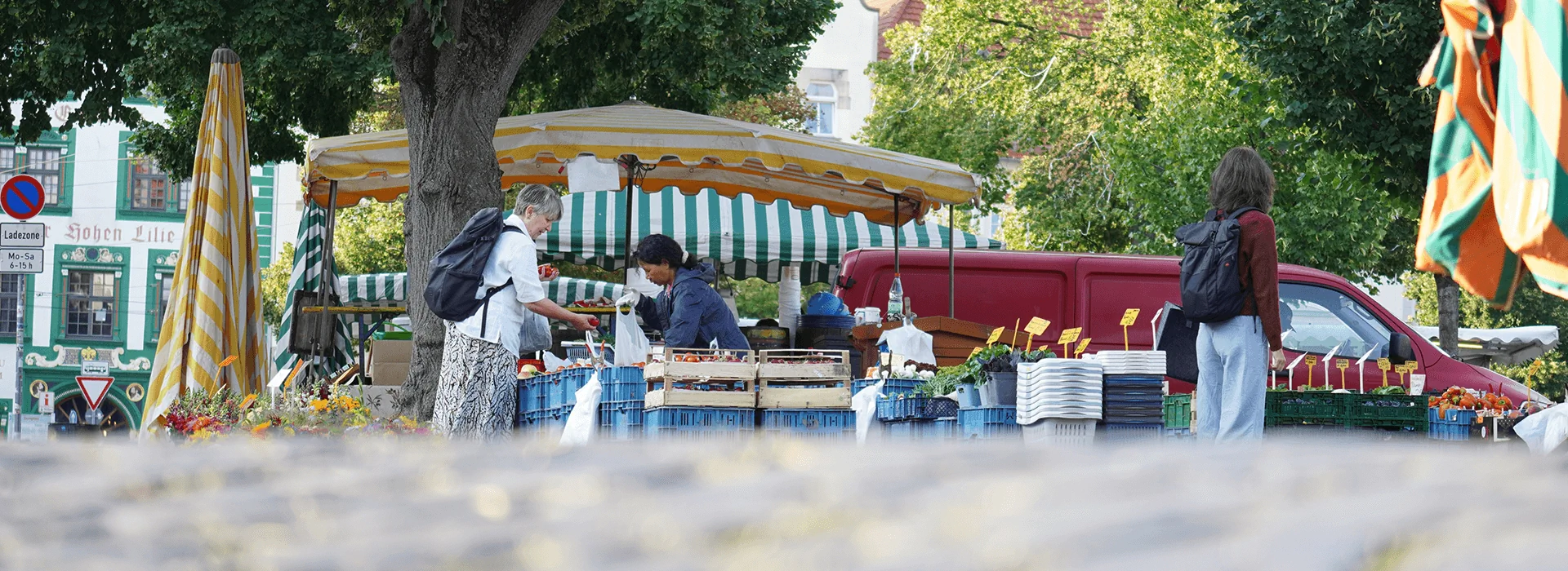 Bildbeschreibung / description: Menschen unterhalten sich an einem Marktstand in Erfurt an einem sonnigen Tag im Schatten