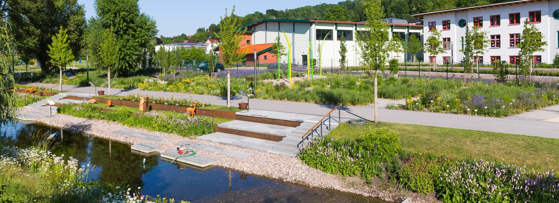 Bildbeschreibung / description: Ein Fluss, der durch einen Park fließt, umgeben von Bäumen und Grünflächen, ideal für Erholung und Naturgenuss.
