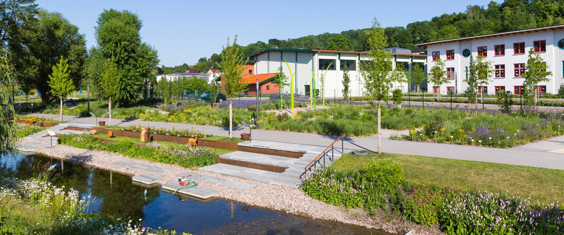 Bildbeschreibung / description: Ein Fluss, der durch einen Park fließt, umgeben von Bäumen und Grünflächen, ideal für Erholung und Naturgenuss.