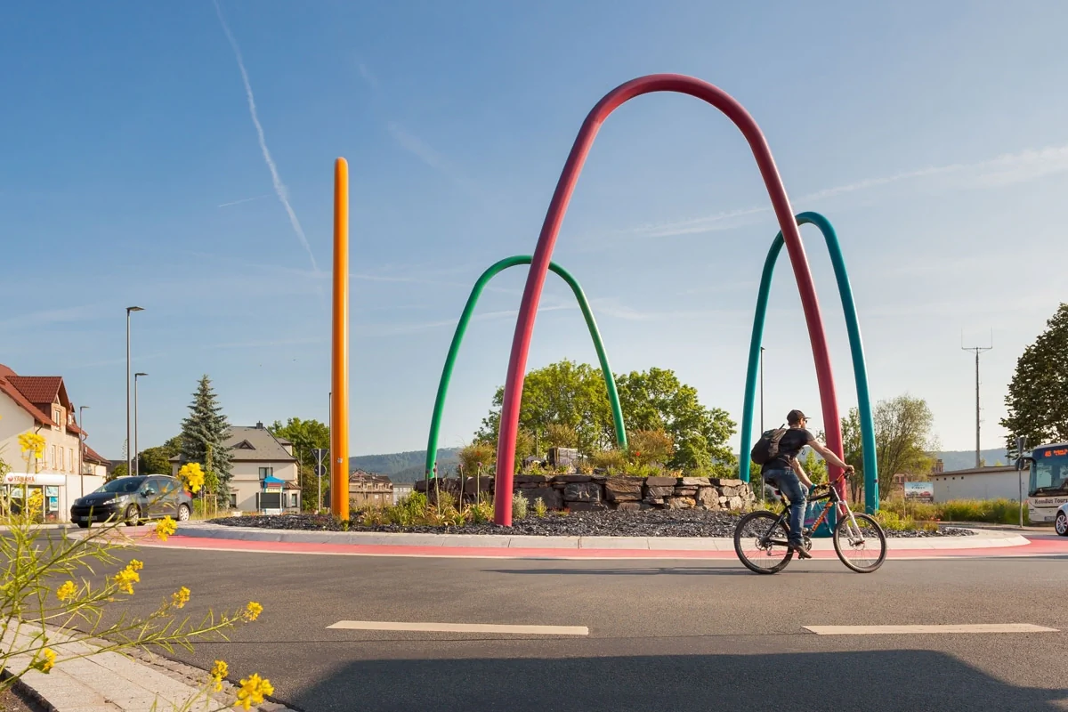 Stadtsanierung Bildbeschreibung / description: Kreisverkehr in Saalfeld mit 4 großen bunten Bögen aus Metall im Zentrum