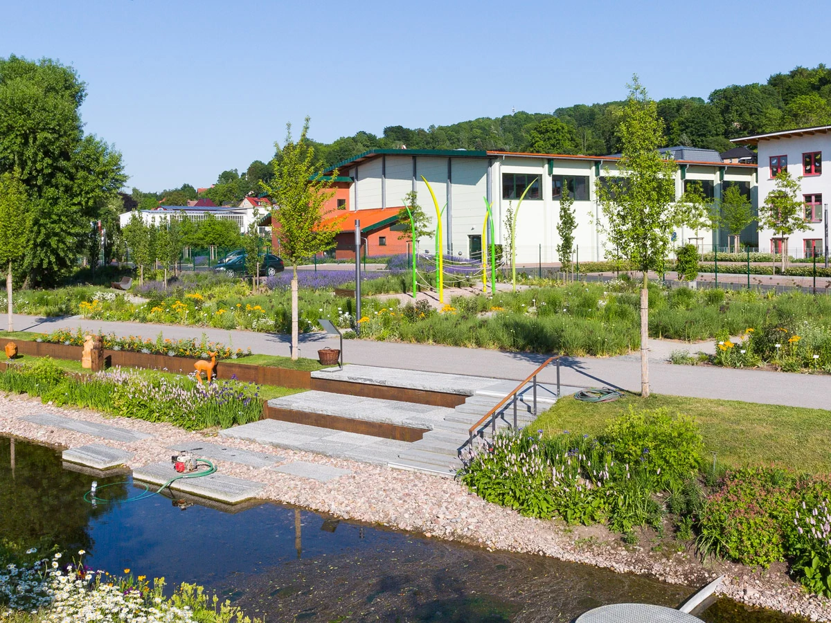 Bildbeschreibung / description: Ein Fluss, der durch einen Park fließt, umgeben von Bäumen und Grünflächen, ideal für Erholung und Naturgenuss.