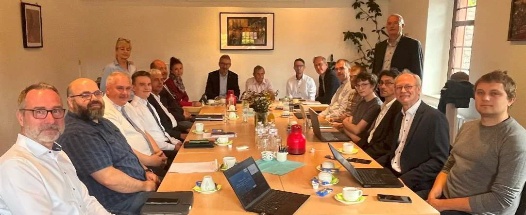 ÖPNV-Konferenz zur Überwindung der Grenzen und Abstimmung der Planungsziele in der Grenzregion von Thüringen und Sachsen-Anhalt Bildbeschreibung / description: Projektbeteiligte sitzen gemeinsam an einer Tafel und schauen in die Kamera